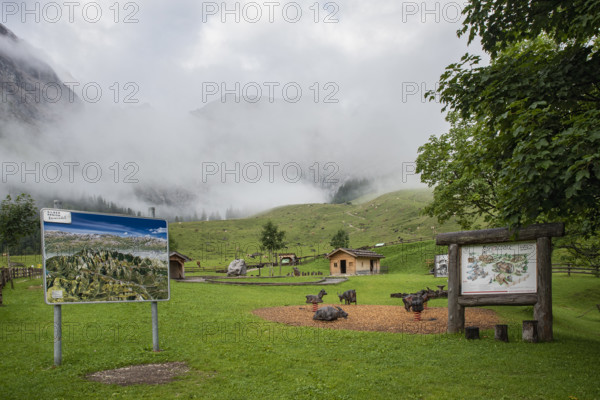 Playground and panorama board in Almdorf Eng with fog, Tyrol, Austria