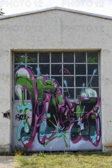 Garage door decorated with colourful graffiti and abstract shapes, at the port of Linz Upper
