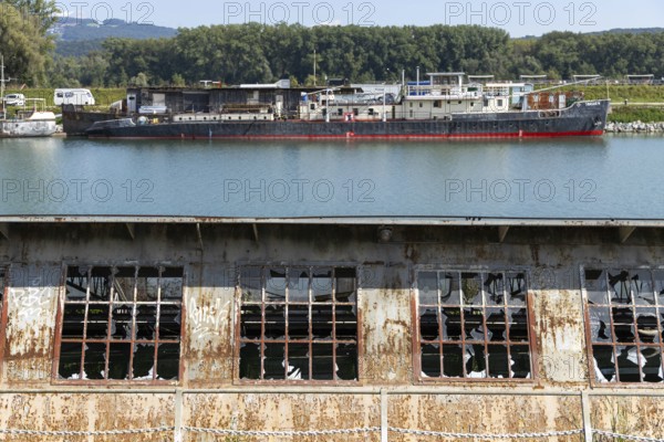 Industrial landscape with abandoned plant and ships in the background, at the harbour of Linz Upper