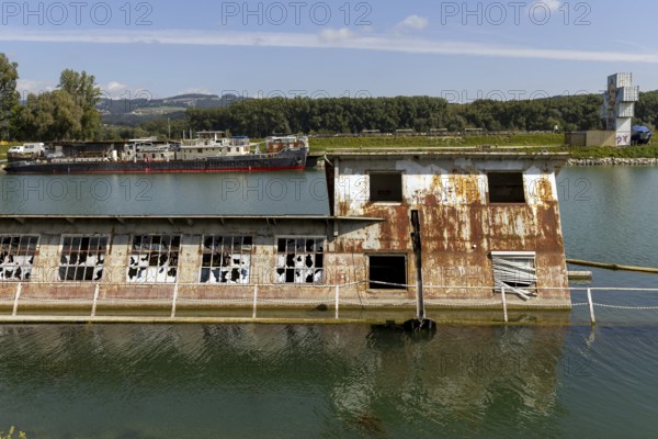 Rusty, dilapidated building on the water in a natural environment, at the harbour Linz Upper