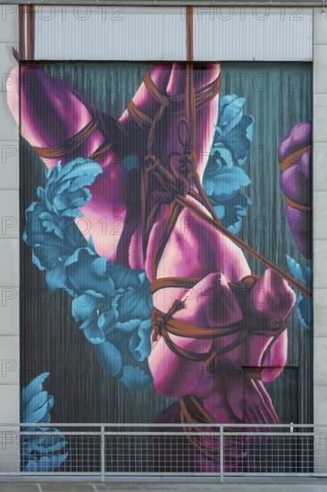 Colourful depiction of a body decoratively wrapped with flowers and ribbons, at the port of Linz,