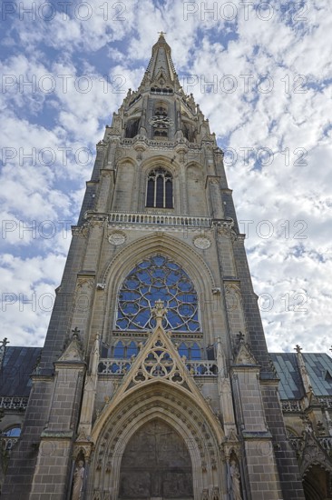 Gothic church façade with detailed stained glass windows and cloudy sky, Maria Empfängnis Dom Linz