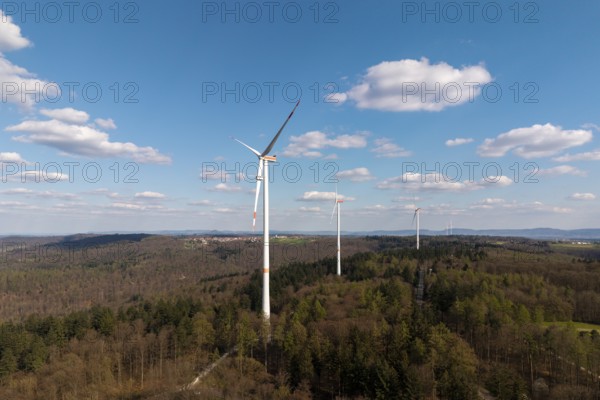 Green landscape with wind turbines and slightly cloudy sky, maintenance work, repair, near