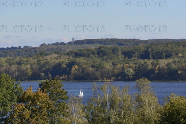 View of the Möhnesee with sailing boat and the Möhnesee tower, autumn atmosphere, blue sky,