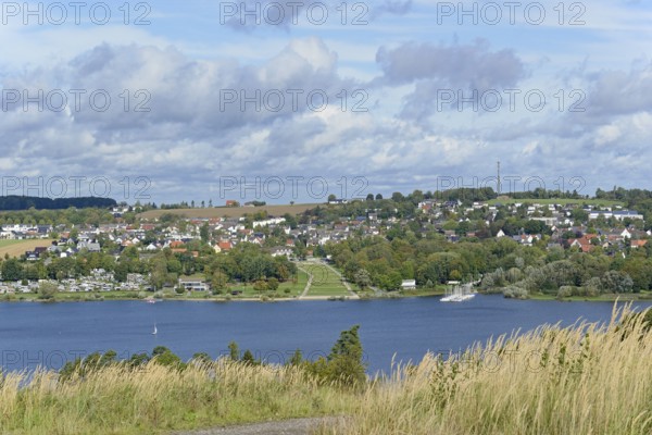 View over the Möhnesee, Körbecke village with the lake park and the lakeside promenade, blue cloudy
