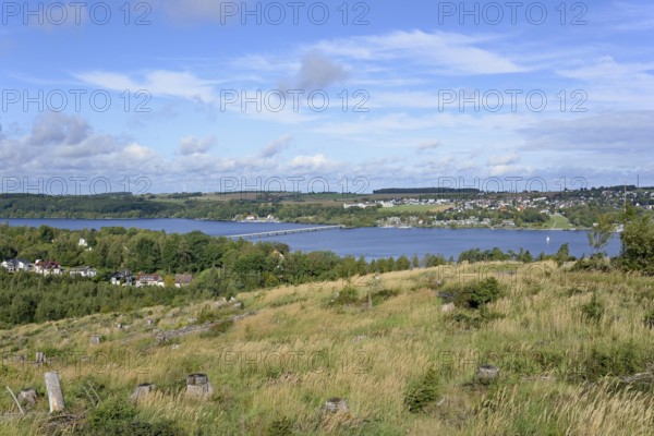 View over the Möhnesee, Körbecke village with the lake park and the lakeside promenade, blue cloudy