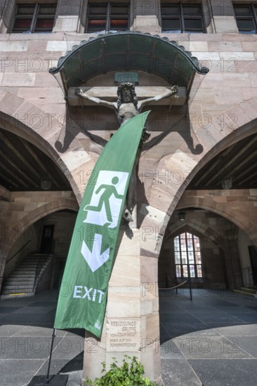 Exit sign in front of a Christ cross in the courtyard of the Heilig Geist Spital, Nuremberg, Middle