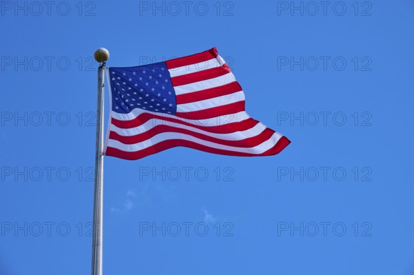 Stars and Stripes waving on a pole under a clear sky, Flamingo, Everglades National Park, Florida,