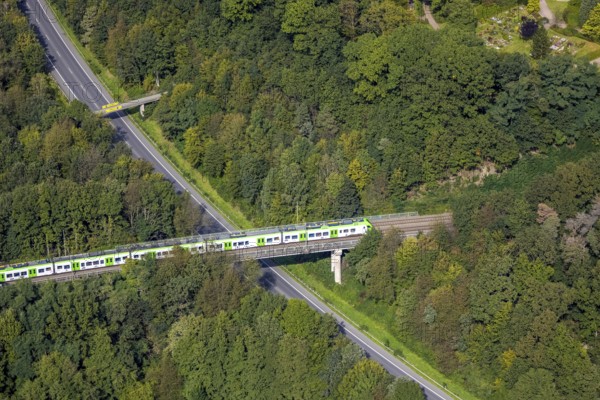 Aerial view, suburban railway crossing a bridge and adjacent pedestrian bridge over the