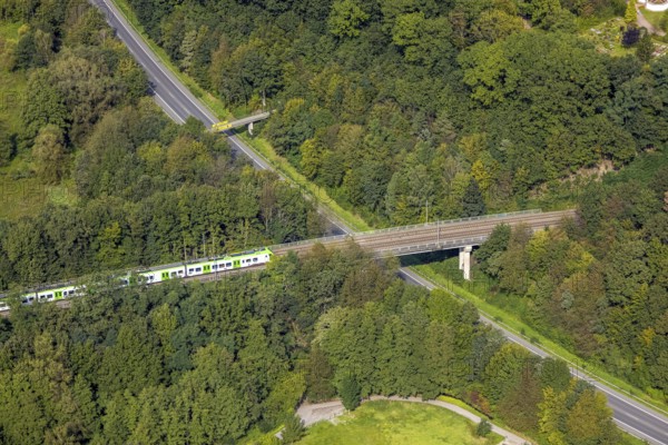 Aerial view, suburban railway crossing a bridge and adjacent pedestrian bridge over the