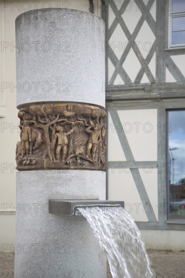 Market fountain with relief on the town's history, water jet, market square, Haldensleben,