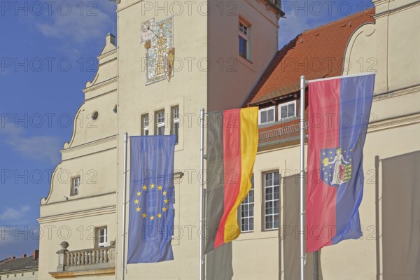 Renaissance town hall with EU flag, German national flag and town flag, three, flags, sundial, wall