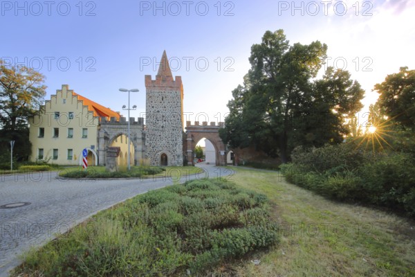 Historic Heath Gate with town wall and building with stepped gable in backlight, town