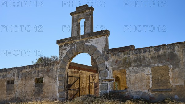 Dilapidated archway of an old factory, surrounded by crumbling walls under a clear sky, Old silk