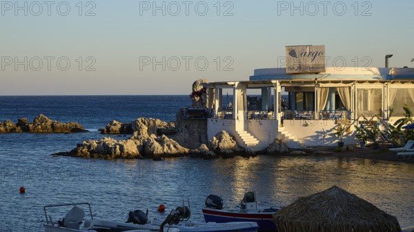 Restaurant Argo, evening mood at a restaurant with sea view and small boats in front of rocky