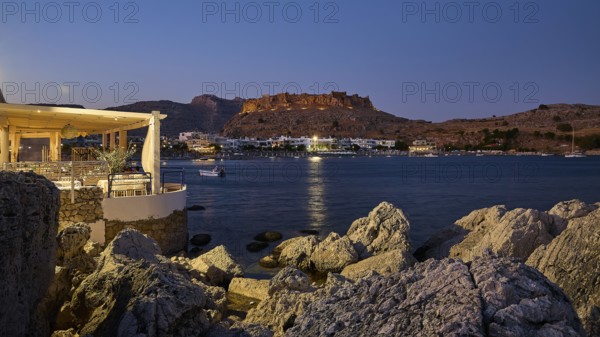 Argo restaurant, Feraklos fortress, night view of a castle above a quietly lit coastal town by the