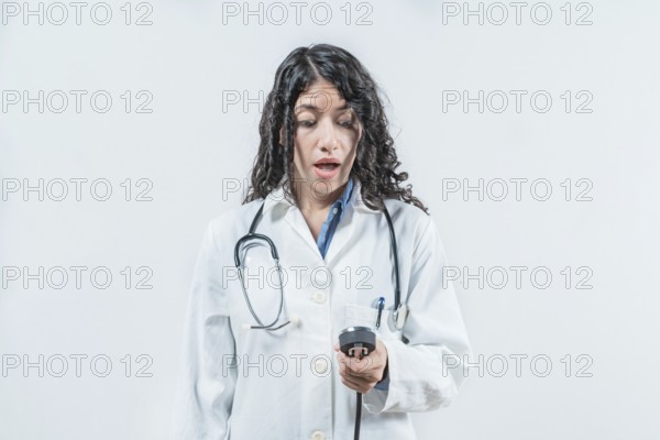 Surprised female doctor with blood pressure monitor isolated. Surprised doctor with blood pressure