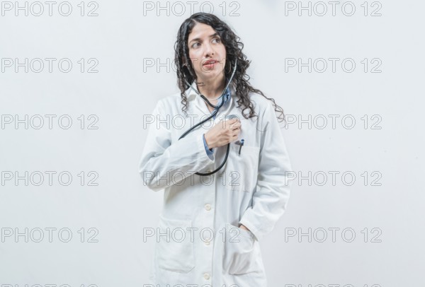 Doctor listening to her heart with stethoscope, isolated. Female doctor with stethoscope on her
