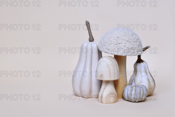 Decorative mushroom and pumpkin ornaments on beige background with copy space. Autumn seasonal
