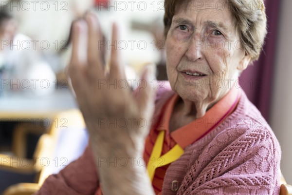 Over 90-year-old senior citizen with dementia talks and gesticulates with her wrinkled hands in a