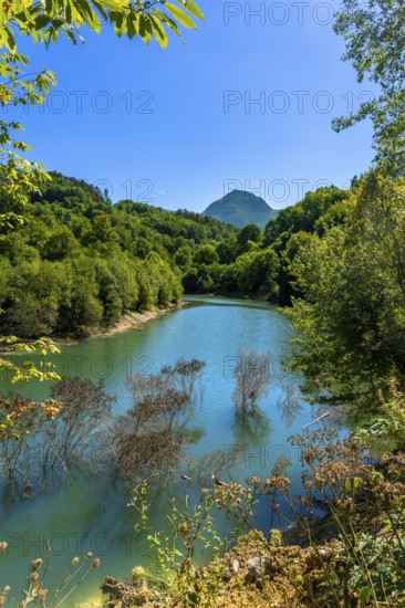 Ibiur reservoir reflecting vibrant trees and a majestic mountain adorned with lush vegetation on a
