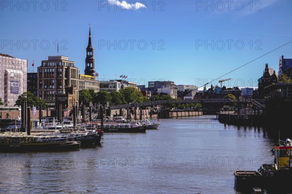 A busy harbour with many boats, a bridge and urban architecture under a clear sky. View from the