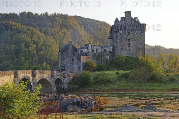 Historic castle on an inlet with dramatic mountains in the background, Eilean Donan Castle,