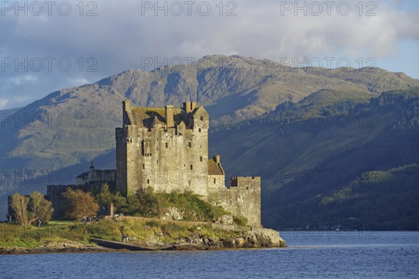 Historic castle on an inlet with dramatic mountains in the background, Eilean Donan Castle,