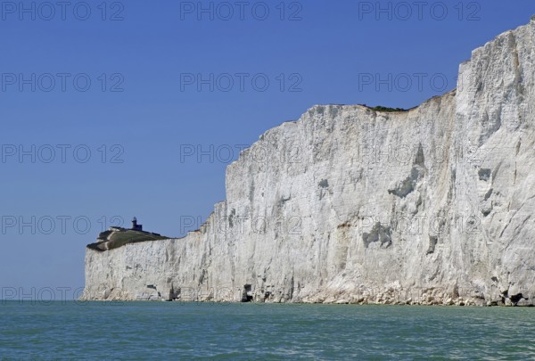 Wide cliff landscape with a small lighthouse under a blue sky. Old Harrys Rock, Bournemouth,