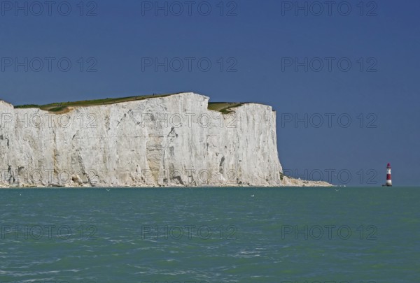 White cliffs on turquoise sea with view of red lighthouse, Old Harrys Rock, Beachy Head Lighthouse,