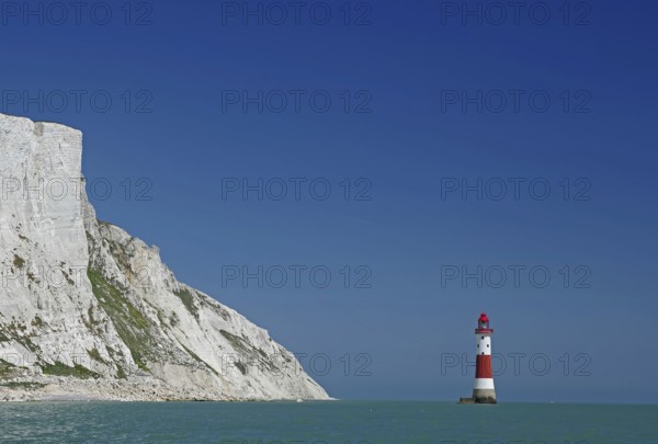 Red lighthouse in front of white cliffs at the blue sea, Old Harrys Rock, Beachy Head Lighthouse,