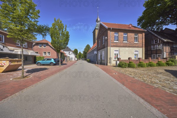 Street, church tower of St. Johannis, brick building, trees, blue sky, cirrostratus clouds, main