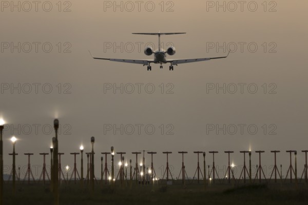 Bombardier Global business jet passenger aircraft in flight landing at sunset at London Stansted