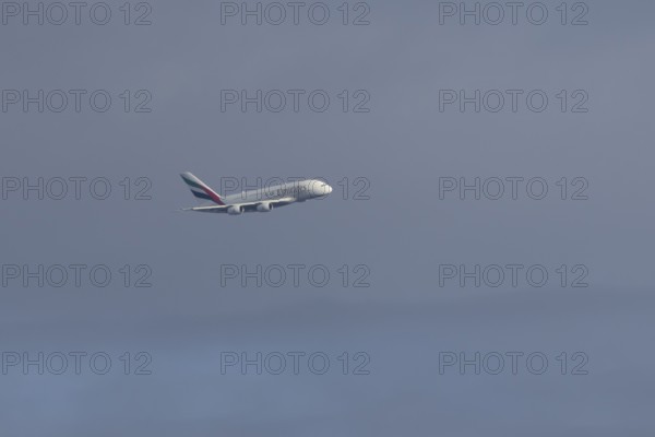 Airbus A380 jet passenger aircraft of Emirates airlines flying in a blue sky, England, United