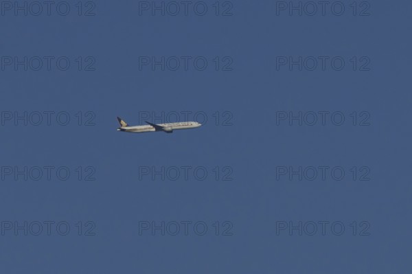 Boeing 777 jet passenger aircraft of Singapore airlines in flight in a blue sky, England, United