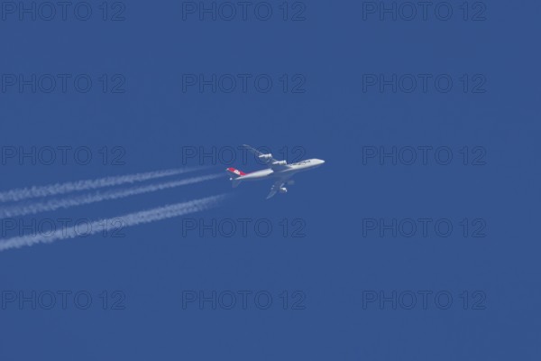 Boeing 747 Jumbo jet cargo aircraft of Cargolux airlines in flight in a blue sky with vapour trails
