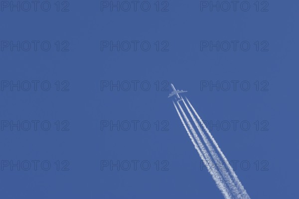 Airbus A340-300 jet aircraft of Lufthansa airlines in flight in a blue sky with vapour trails or