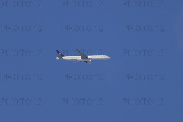Boeing 777 jet passenger aircraft of Saudi airlines in flight in a blue sky, England, United