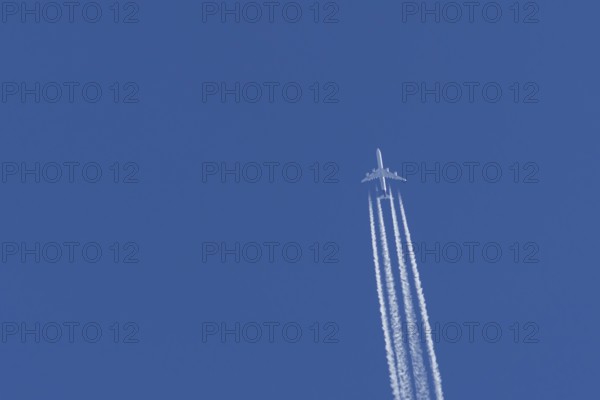 Airbus A340-300 jet aircraft of Lufthansa airlines in flight in a blue sky with vapour trails or