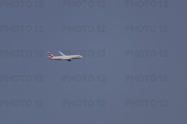 Boeing 787-9 Dreamliner jet passenger aircraft of British Airways airlines in flight in a blue sky,