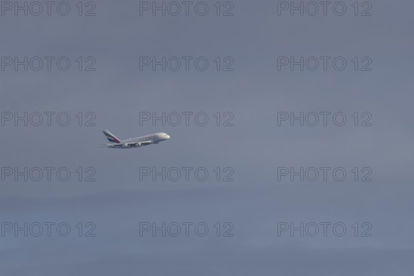 Airbus A380 jet passenger aircraft of Emirates airlines flying in a blue sky, England, United