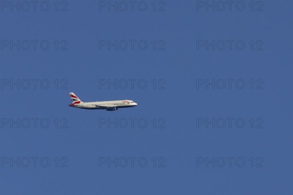 Airbus A320-232 jet passenger aircraft of British Airways airlines in flight in a blue sky, London,