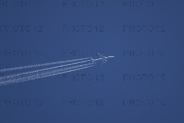 Airbus A340-300 jet aircraft of Lufthansa airlines in flight in a blue sky with vapour trails or