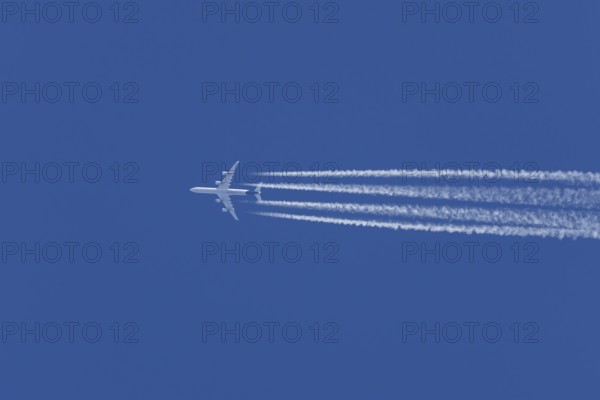 Airbus A340-300 jet aircraft of Lufthansa airlines in flight in a blue sky with vapour trails or
