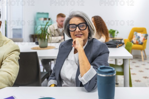 Experienced senior businesswoman smiling confidently during a meeting in a modern office,