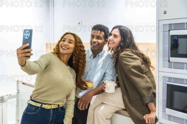 Group of diverse colleagues enjoying a coffee break in the office kitchen, smiling and posing