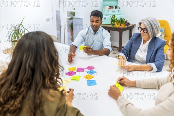 Diverse business team collaborating and exchanging ideas in a creative meeting, using colorful