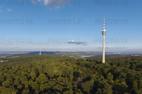 Sublime television tower above a green forest landscape with blue sky and clouds,