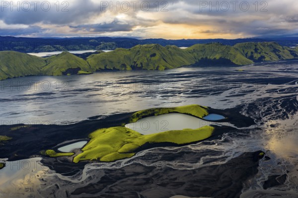 Turquoise-coloured crater lake with moss-covered crater rims in the Icelandic highlands, surrounded
