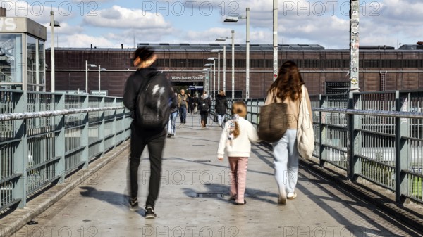 People walking across a bridge at Warschauer Straße station, Berlin, 02 October 2025, Berlin,